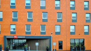 A modern hotel building with a brick facade, multiple windows, and a sign for 'ibis Lyon Chapoucy'. - ibis Lyon Est Chaponnay (Chaponnay)
