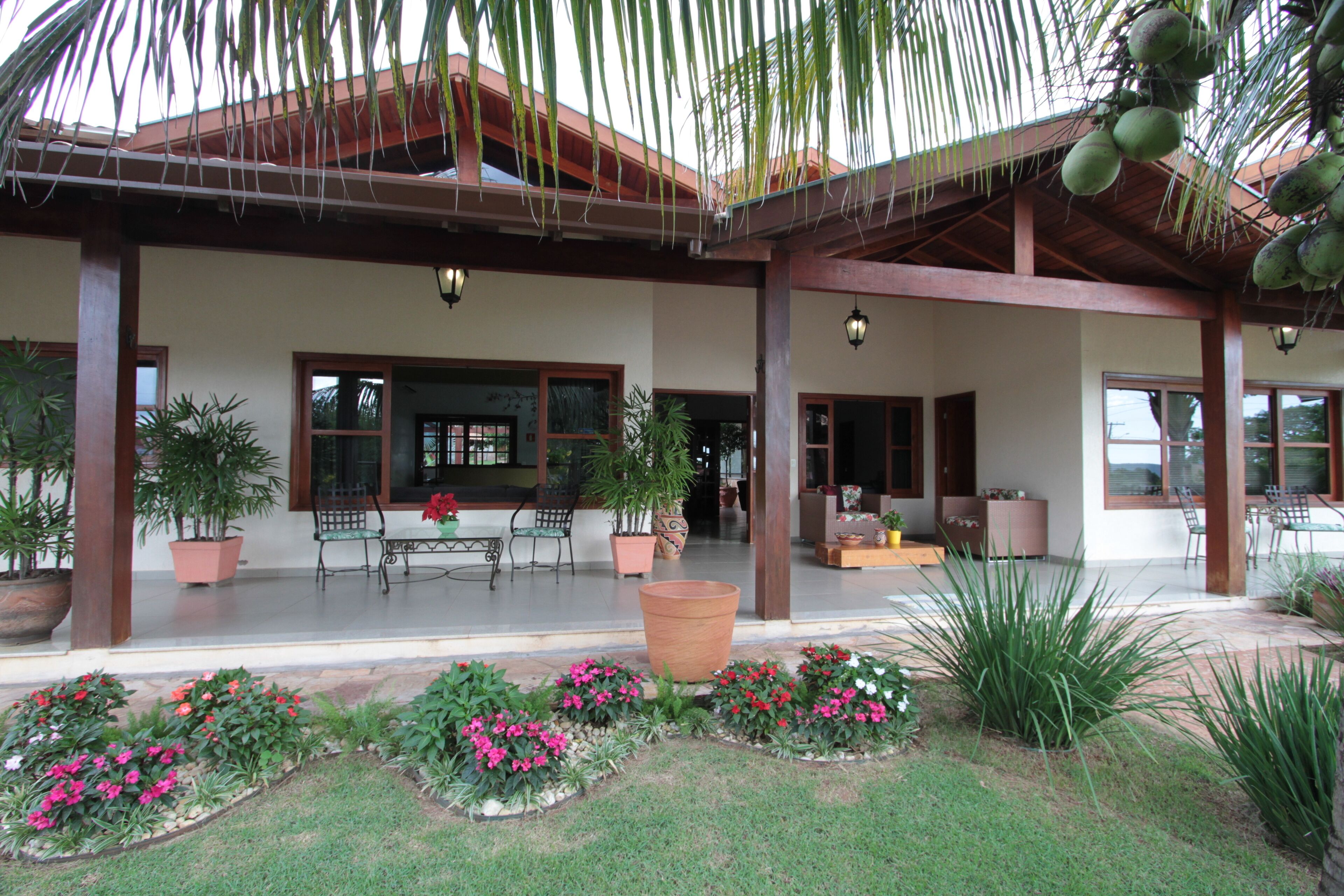 A covered outdoor area with seating, potted plants, and a patio.