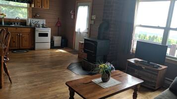 A cozy living room with a fireplace, a television, and a dining area with wooden furniture.