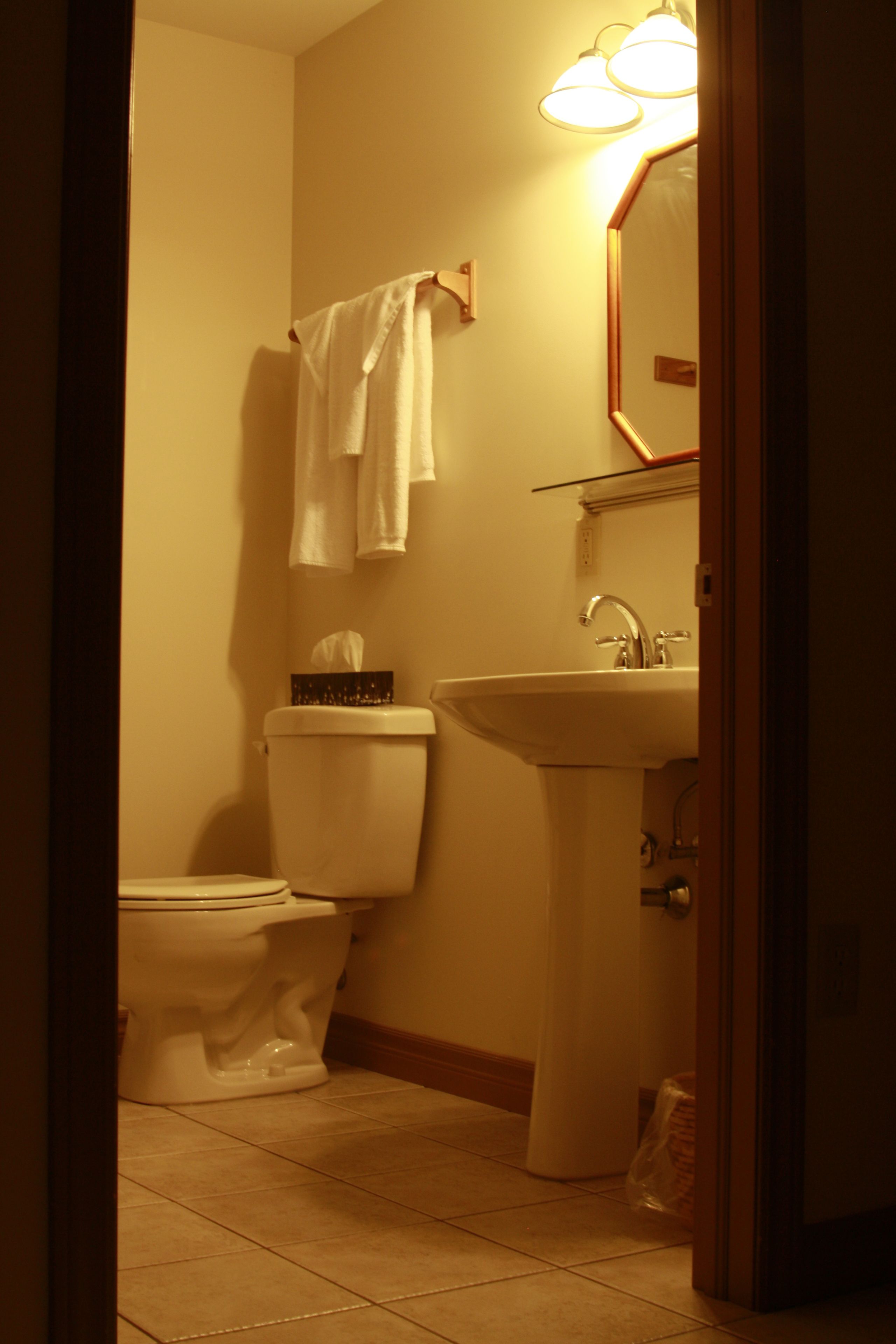 Un baño pequeño con inodoro, lavamanos y espejo.