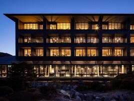 Un hôtel à plusieurs étages doté de balcons, de grandes fenêtres et d’espaces extérieurs aménagés pour s’asseoir.