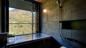 A bathroom with a large window, a shower, and a small wooden stool. - Unzen Miyazaki Ryokan (Unzen)