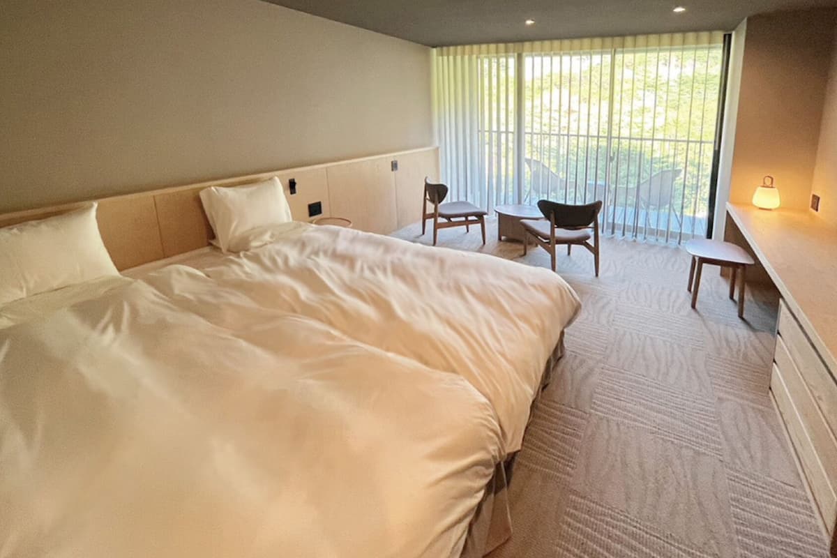 Ein Hotelzimmer mit einem großen Bett, einem Schreibtisch und einem Stuhl.