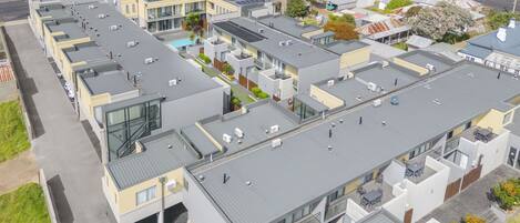 Een modern appartementencomplex met meerdere gebouwen, elk voorzien van een plat dak en zonnepanelen.