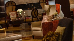 A cozy living room with a fireplace, comfortable seating, and a chandelier.
