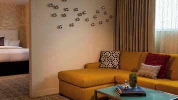 A living room with a sofa, a coffee table, and a wall with decorative metal spheres.