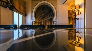 A hotel lobby with a reflective floor, a large arched doorway, and a seating area with velvet chairs. - Majestic Hotel (Tunis)