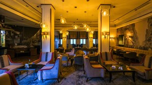 A spacious lobby with multiple seating areas, including sofas and armchairs, and a central coffee table. - Majestic Hotel (Tunis)
