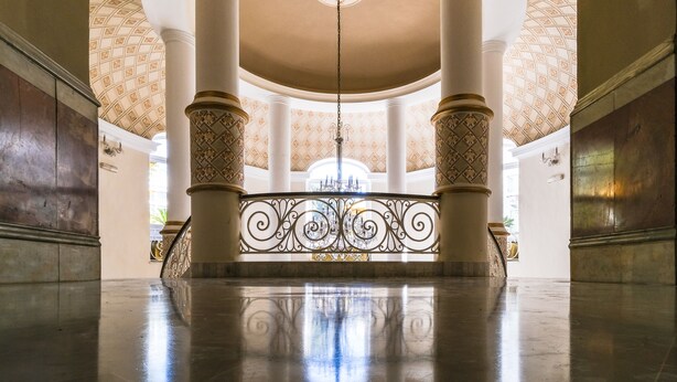A grand hall with a high ceiling, large columns, and a central chandelier. - Majestic Hotel (Tunis)