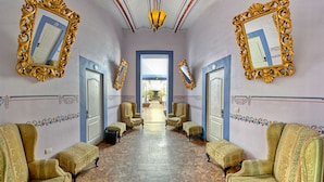 Un corridoio con specchi dorati decorati, pareti a motivi e arredamento classico.