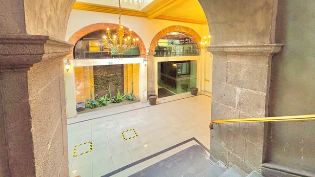 Un'imponente hall con soffitto alto, volte ad arco e un lampadario.