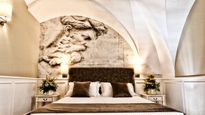 Une chambre avec une grande fresque murale, un lit avec une tête de lit marron, deux tables de chevet avec des lampes et un vase de fleurs sur chaque table.