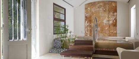 Un interior moderno con una puerta de vidrio, una escalera y una zona de estar.