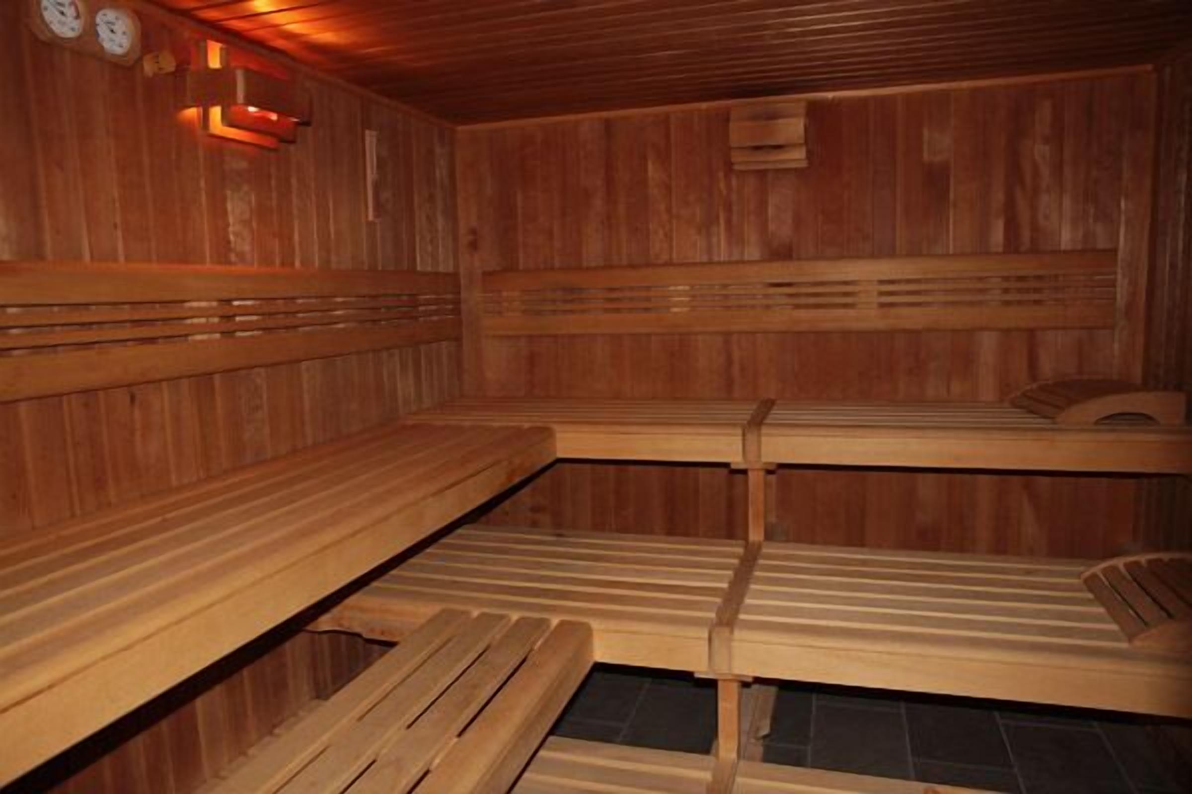 A sauna with wooden benches and a tiled floor.