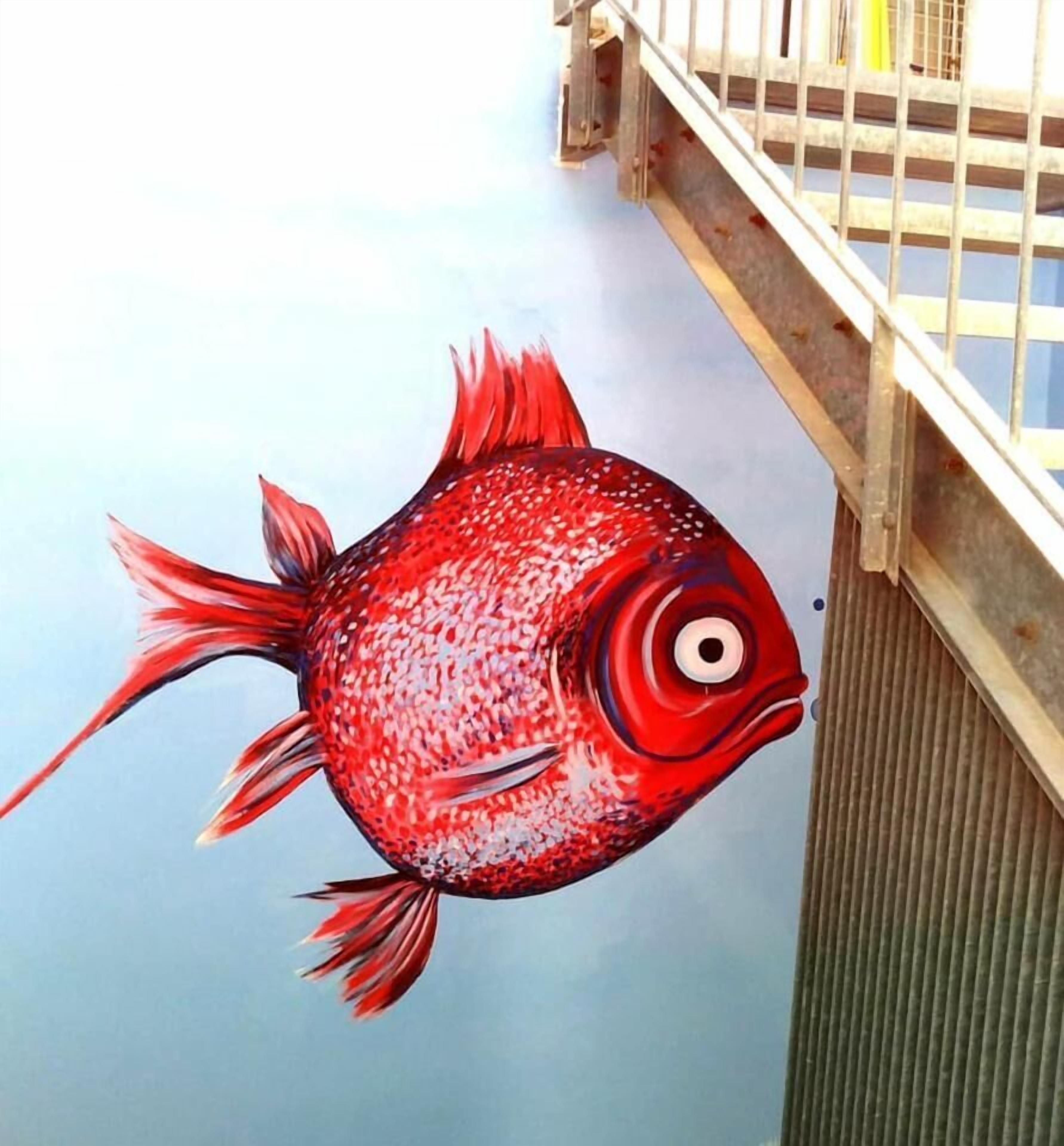 Une fresque représentant des poissons sur un mur.