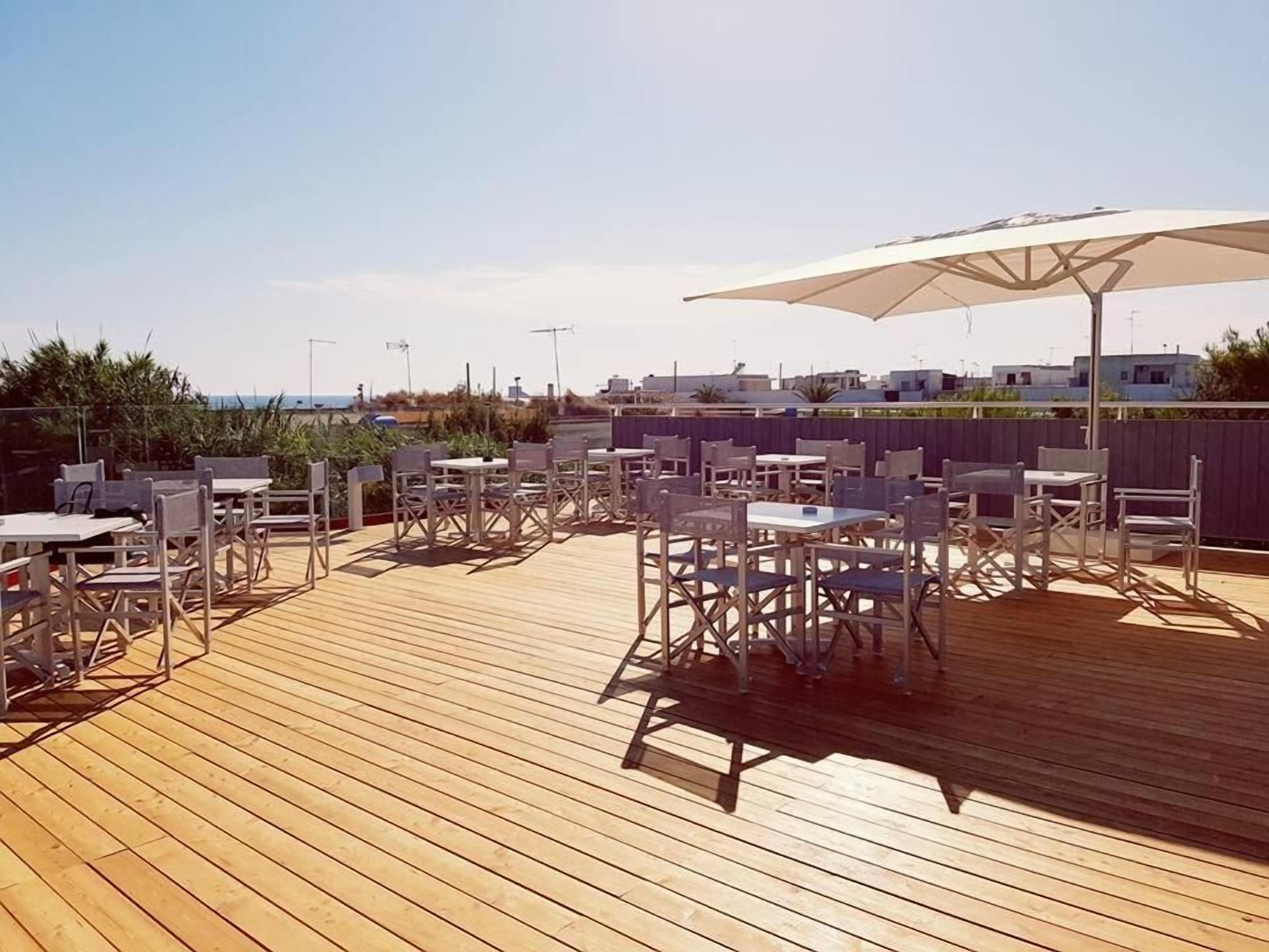 A wooden deck with outdoor seating and a large umbrella.