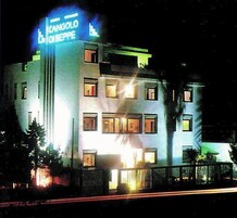 Un hotel de varios pisos con señalización iluminada que dice "CANGOLO DI BIRPE".