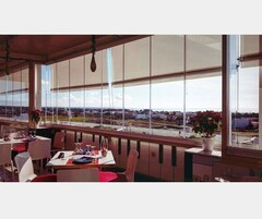 Un restaurante con vistas a un paisaje urbano a través de amplios ventanales.