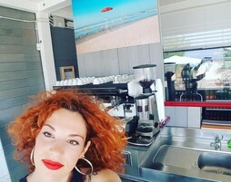 Una máquina de café y un lavamanos en un entorno comercial.