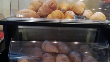 Una teca con due sezioni di prodotti da forno, forse dolci o pane, in un ambiente da panetteria o caffetteria.