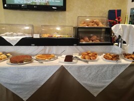 Ein reichhaltiges Buffet mit verschiedenen Speisen, darunter Gebäck, Kuchen und Desserts.
