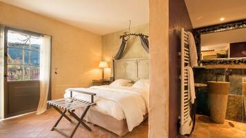 Une chambre à coucher avec un lit, une table de chevet, une lampe, une fenêtre avec des rideaux et une vue sur l’extérieur.