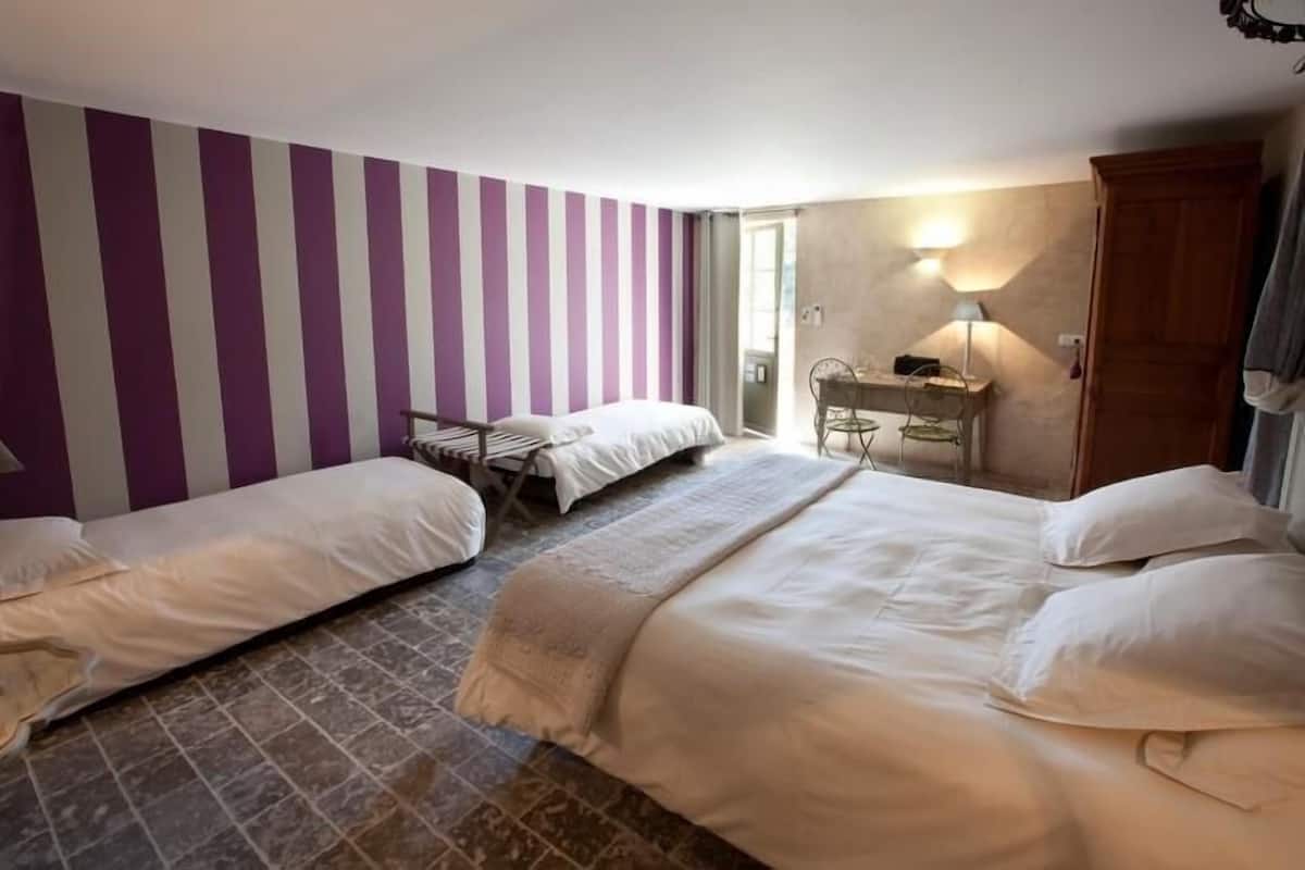 Ein Hotelzimmer mit zwei Betten, einem Schreibtisch und einem Sessel.