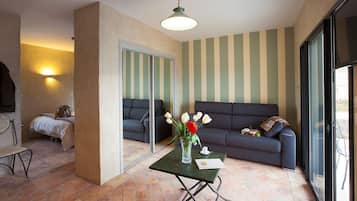 Una sala de estar acogedora con un sofá, una mesita con un florero y un ventanal con vistas.