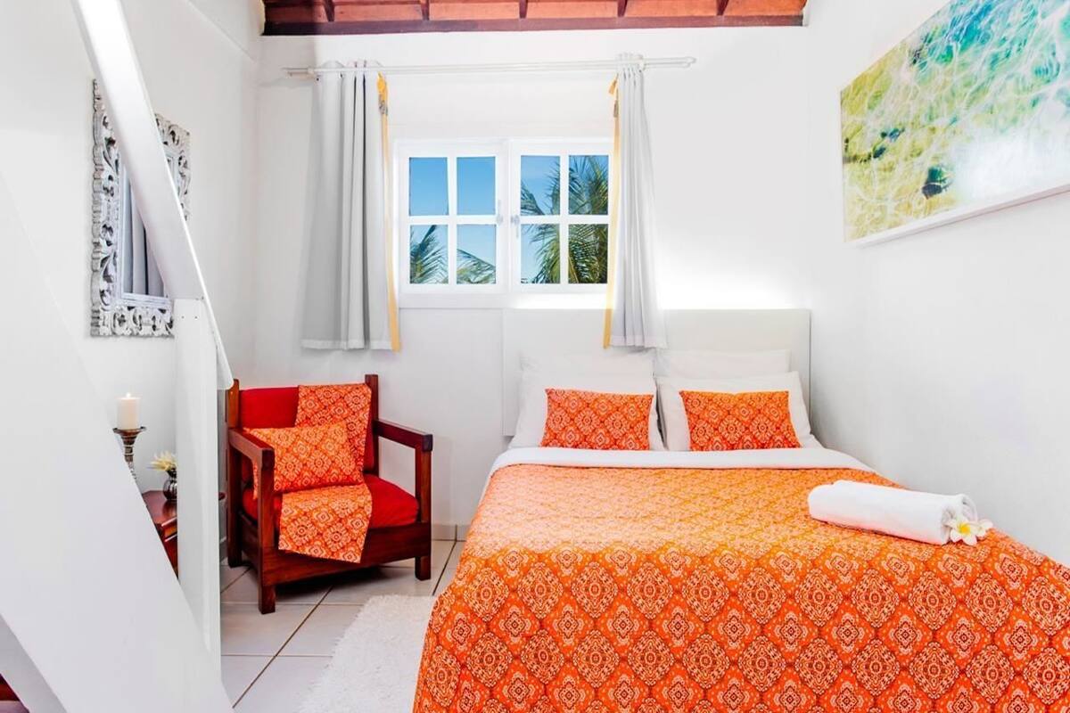 Ein Schlafzimmer mit einem Bett, einem Sessel, einem Fenster und einem Bild an der Wand.