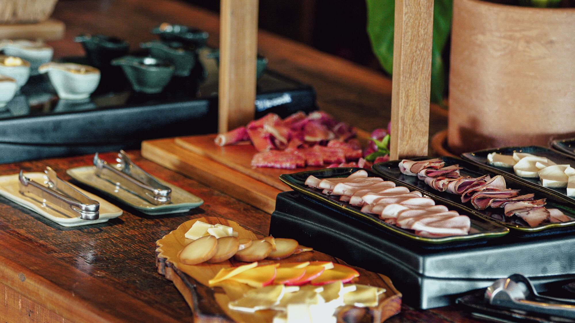 Ein Buffet mit verschiedenen Speisen, darunter Fleisch, Käse und Obst.