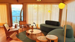 A living room with a sofa, chairs, a coffee table, and a lamp. - Siramat Hotel (Petrópolis)