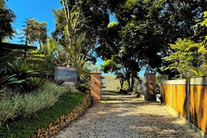 A paved pathway leading to a building entrance with a sign reading 'LE SIRAN.' - Siramat Hotel (Petrópolis)