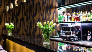 A bar area with a long counter, hanging pendant lights, and bar stools. - Hotel Gromada Koszalin (Koszalin)