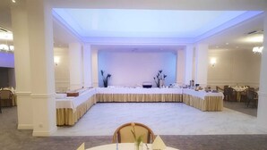 A conference room with a long table, chairs, and a stage. - Hotel Gromada Koszalin (Koszalin)