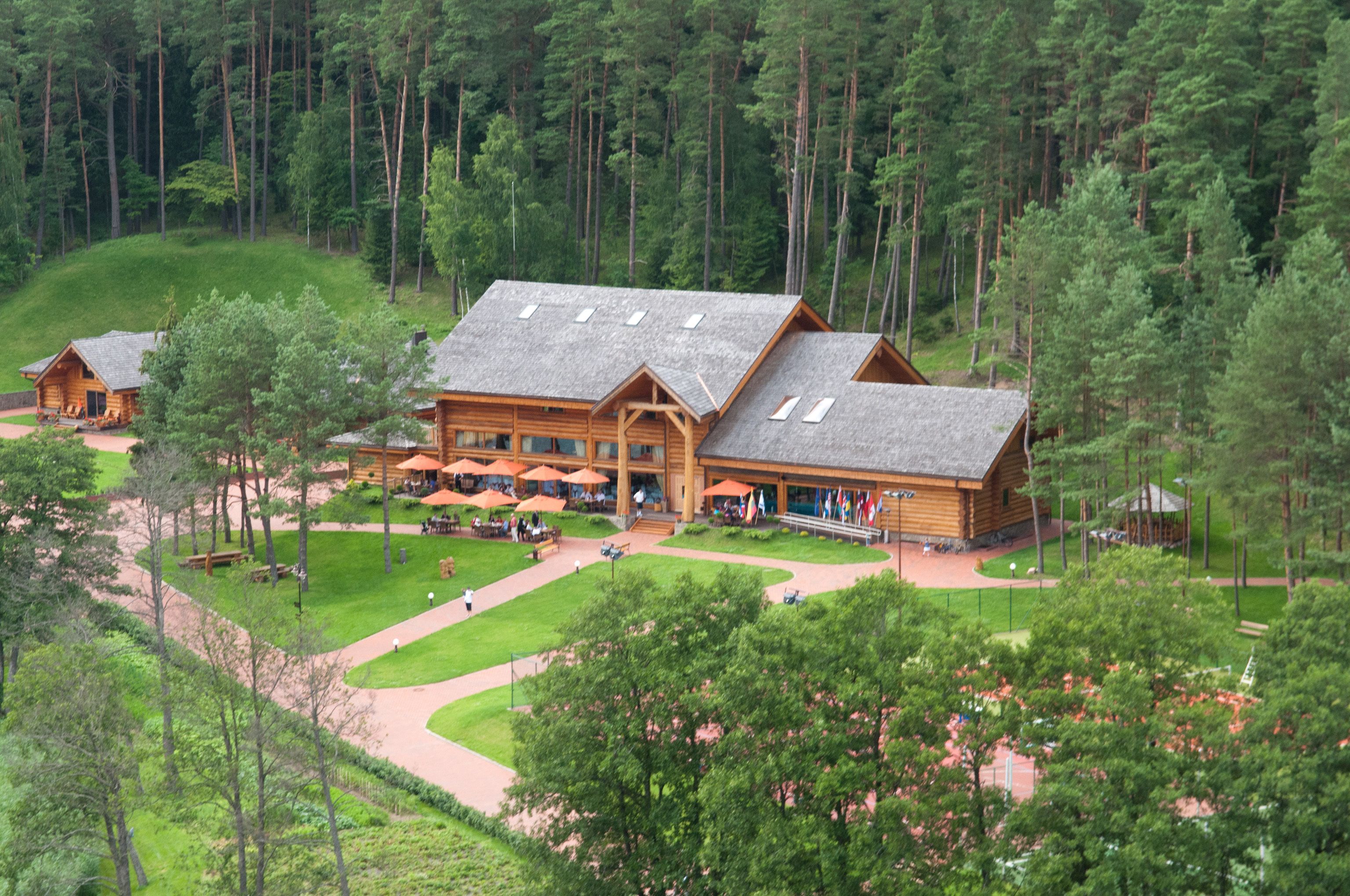 Ein großes Lodge-Anwesen mit mehreren Blockhütten, Sitzgelegenheiten im Freien und einem gepflegten Rasen.