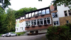 Un immeuble de deux étages à l’architecture moderne, doté de grandes fenêtres et de jardinières au dernier étage.