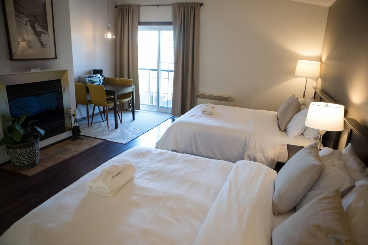 Ein Hotelzimmer mit zwei Betten, einem Schreibtisch und einem Stuhl.