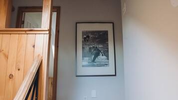 A wooden staircase leading to a room with a framed picture on the wall.