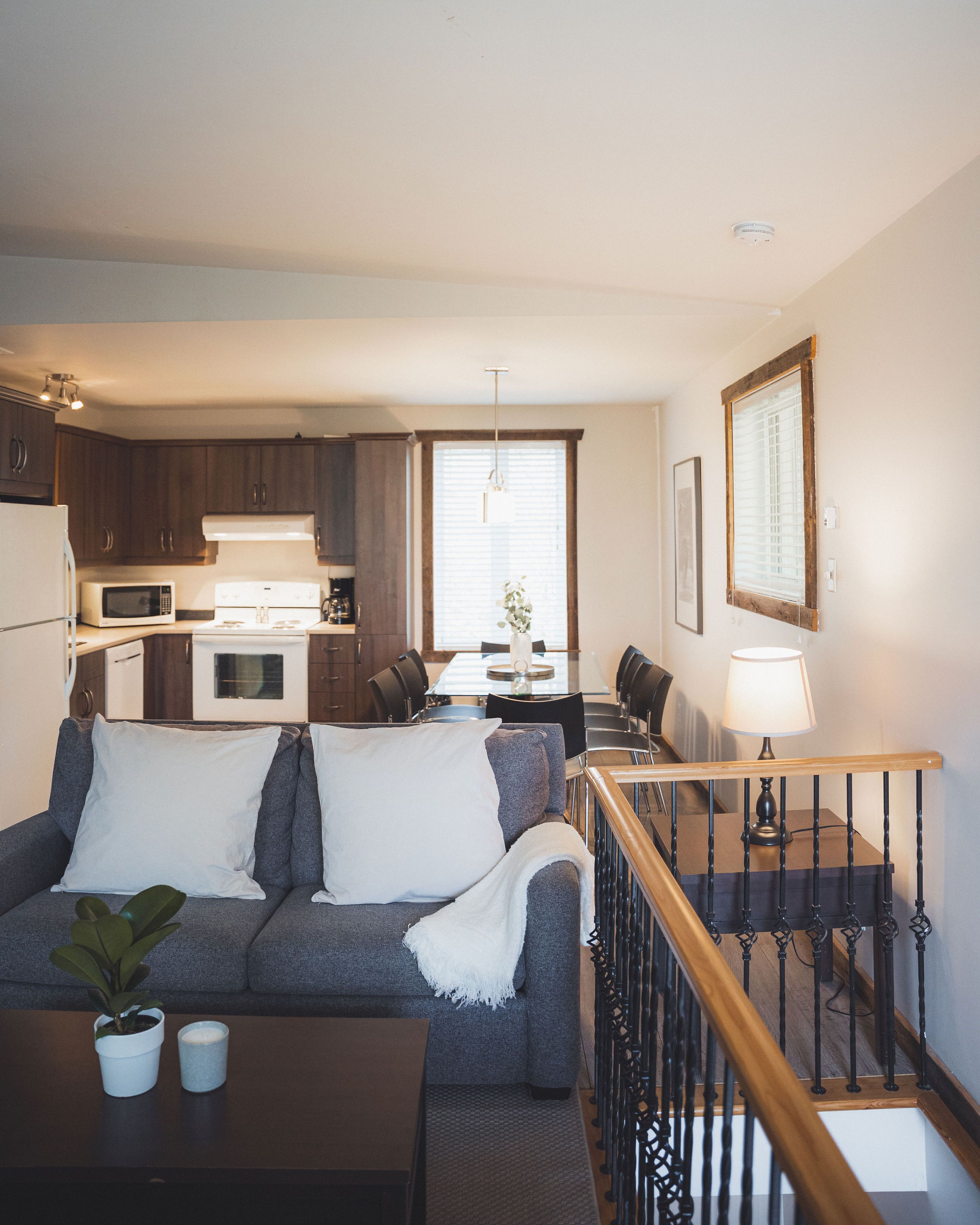 A compact living space with a kitchenette, a dining area, and a staircase.