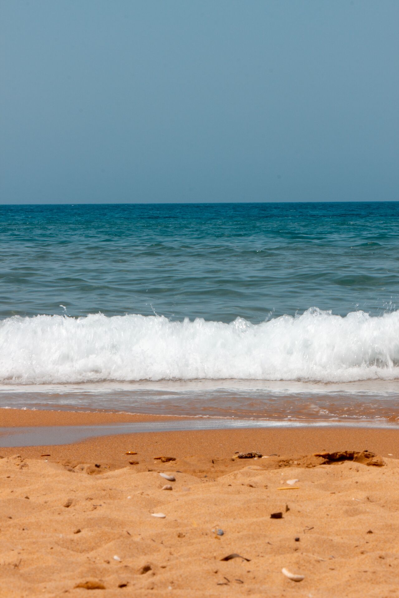 A beach with waves approaching the shore.