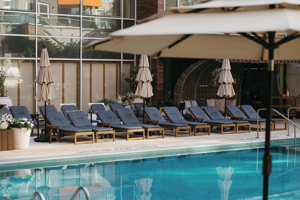 Una piscina al aire libre de temporada, sombrillas