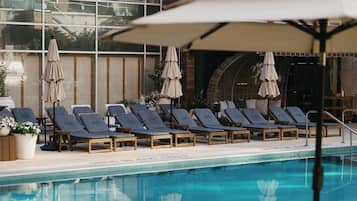 Una piscina al aire libre de temporada, sombrillas