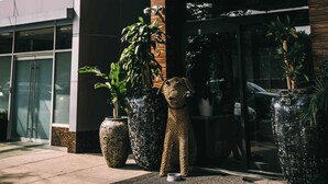 Entrada de un hotel con un cartel que dice "Coda" y una estatua de oso.