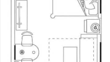 A floor plan of a hotel room with a bathroom, a kitchenette, a seating area, and a bed.