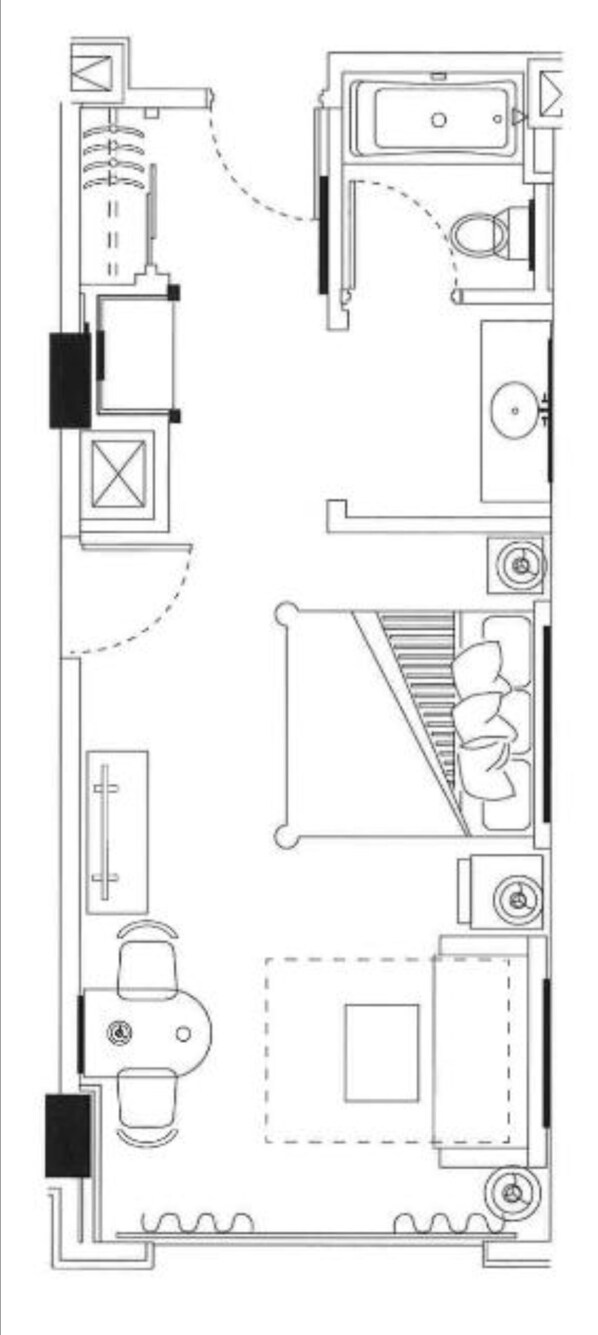 Un plan d’étage d’une chambre d’hôtel comprenant une salle de bain, un coin cuisine, un espace salon et un lit.