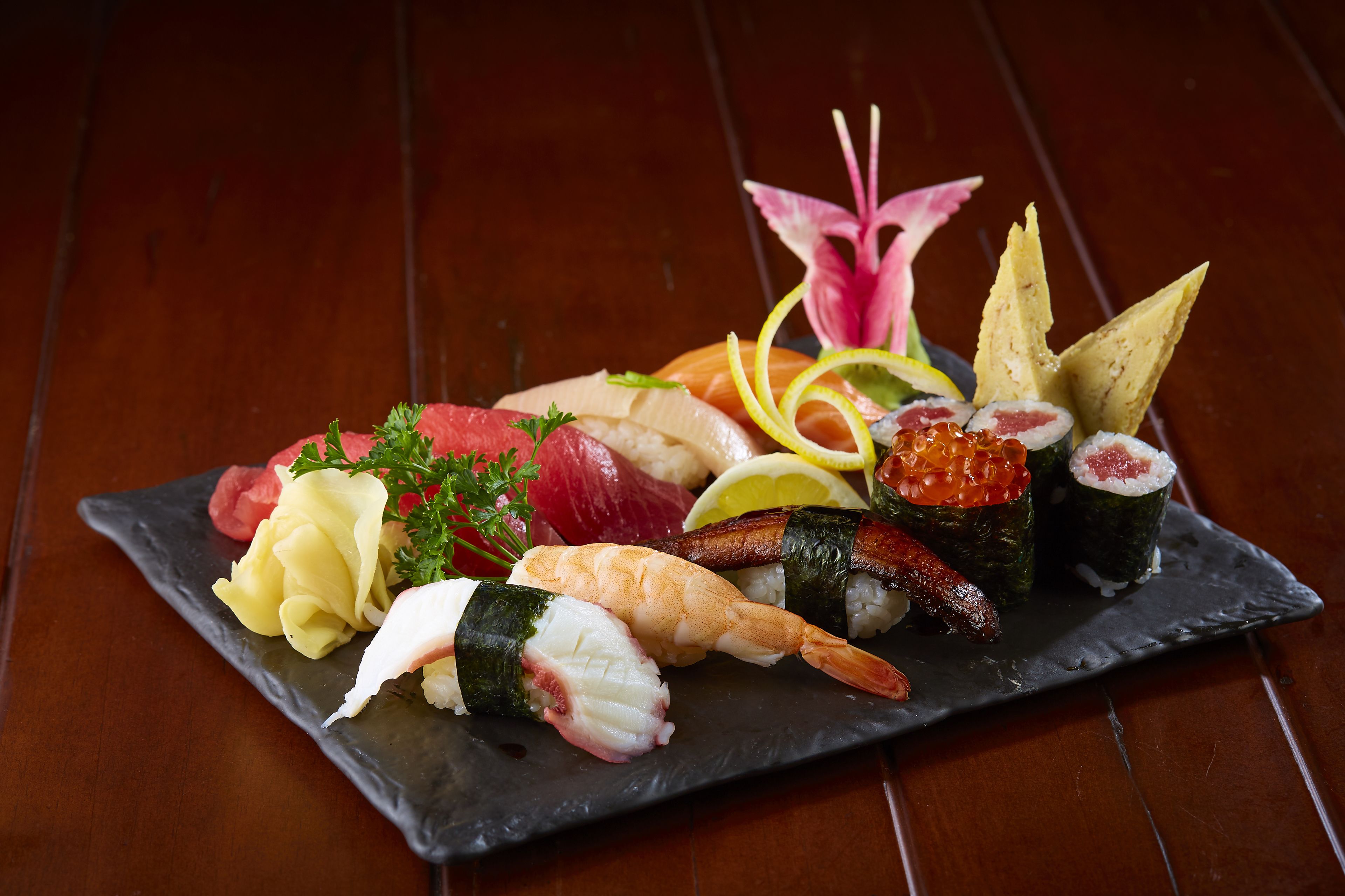 Variedad de sushi sobre un plato de pizarra.