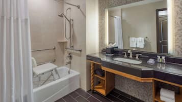Een moderne badkamer met een badkuip, douche, wastafelmeubel en een grote spiegel.