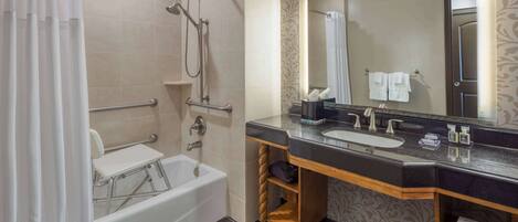 A modern bathroom with a bathtub, shower, vanity with a sink, and a large mirror.