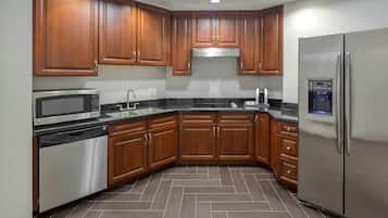 A modern kitchen with wooden cabinets, stainless steel appliances, and a herringbone tile floor.