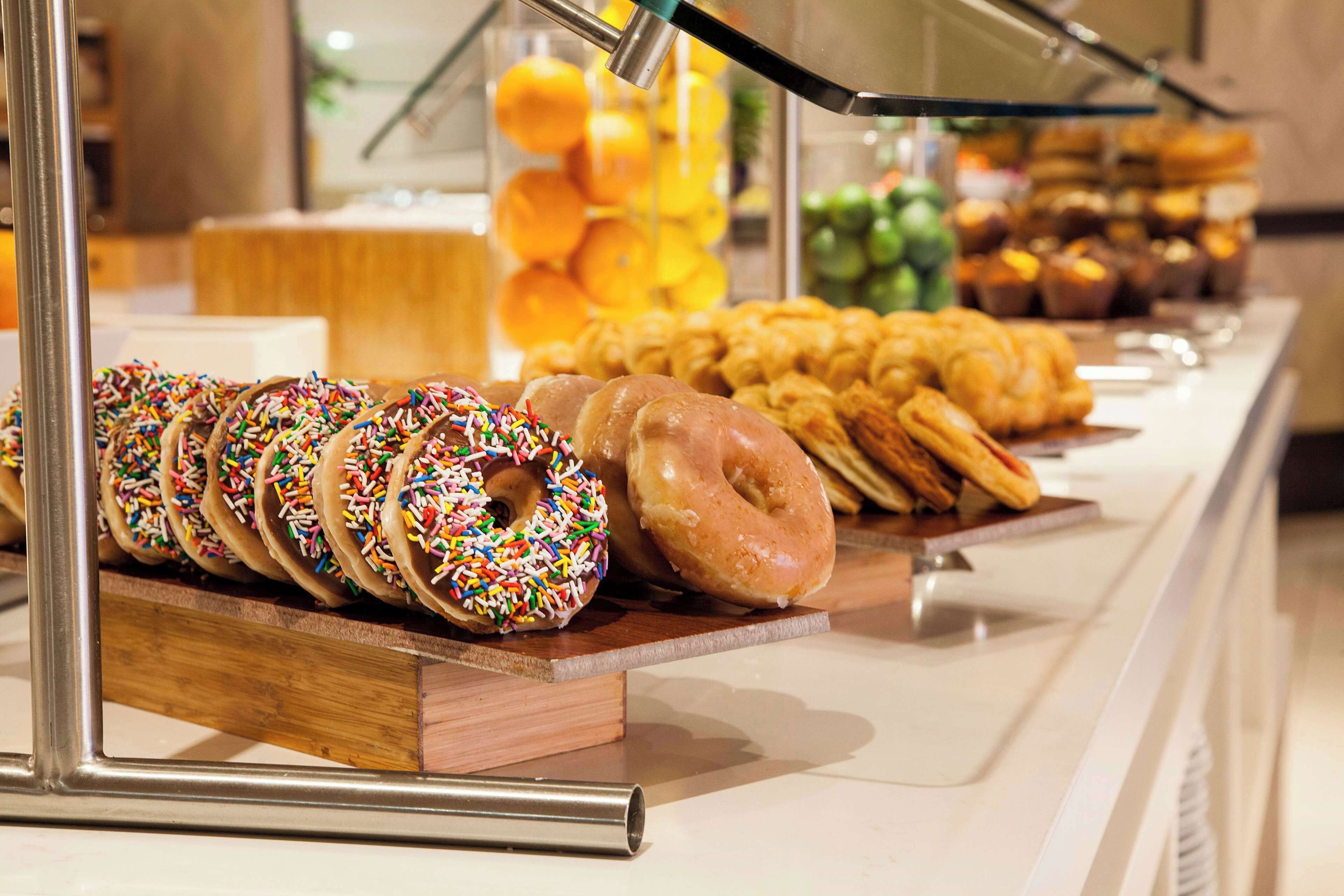 Um buffet de café da manhã com diversos pães e donuts.